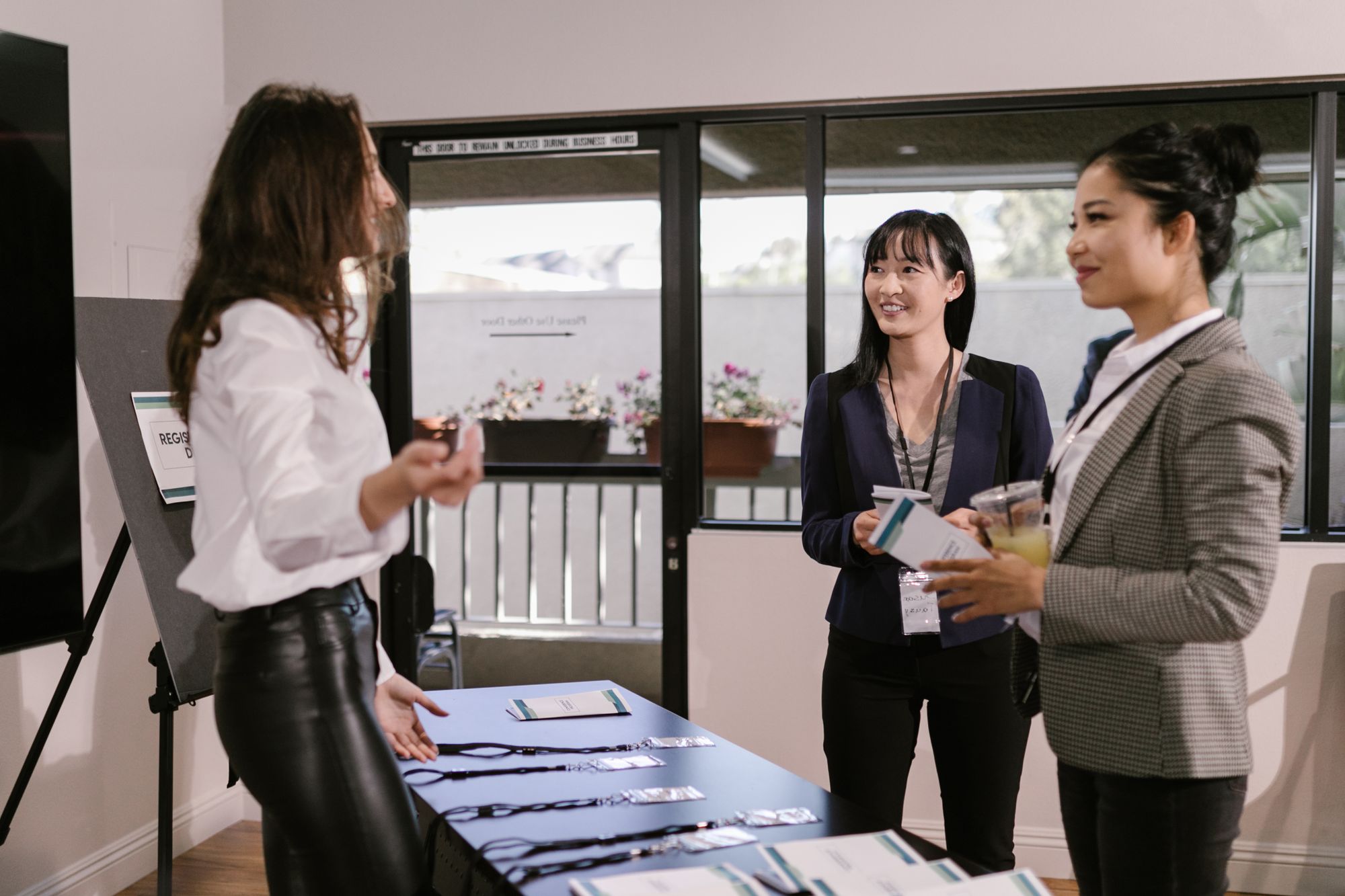 Conference guests with name badges checking in at a seminar registration table