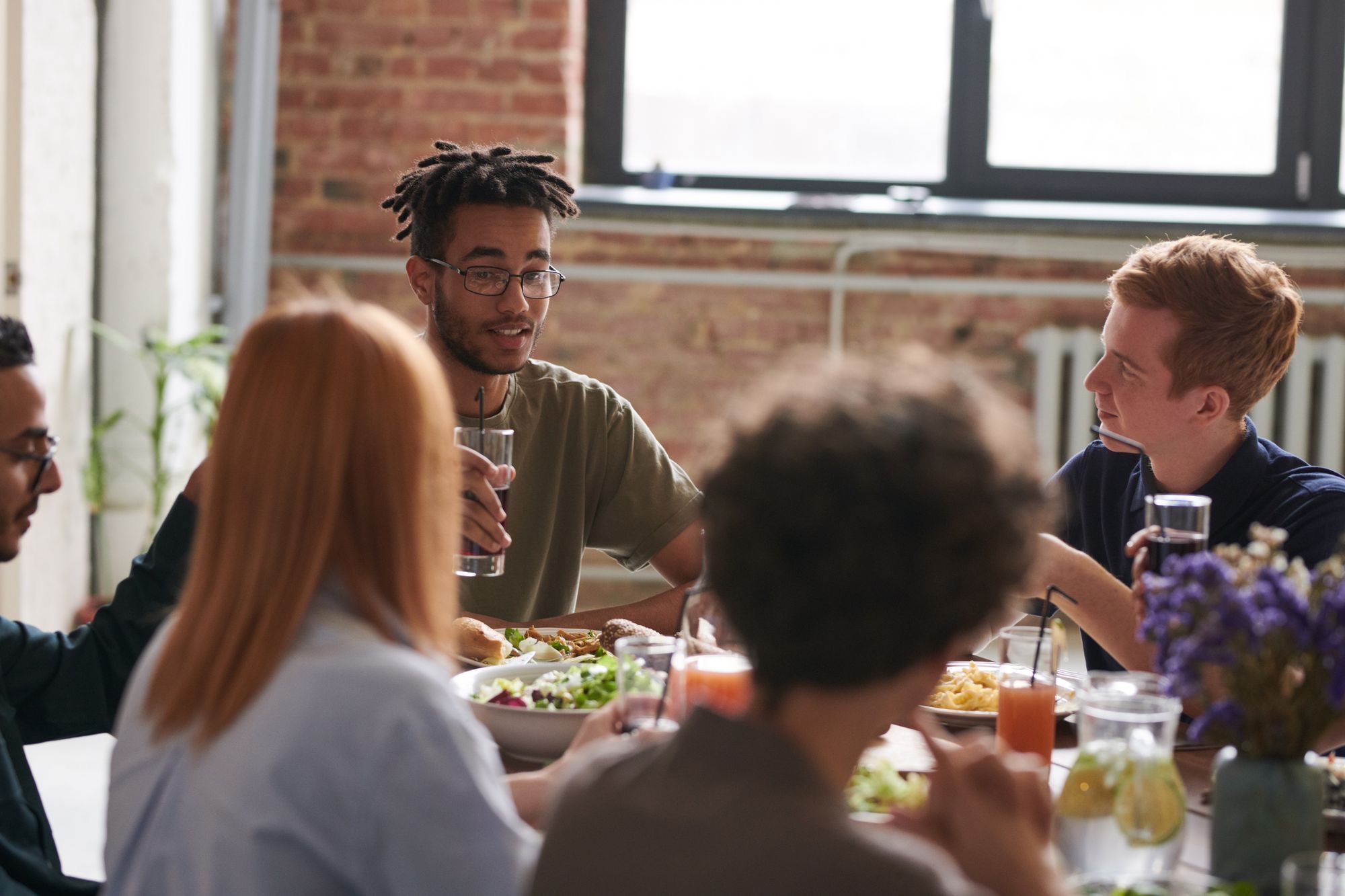 A diverse group of friends sharing a meal and conversation around a table