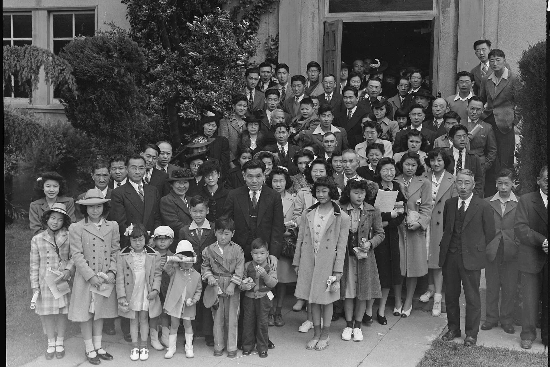 Vintage black-and-white photograph of a Japanese American congregation, from children to elders, gathered on the steps of their church in Oakland, California, in 1942